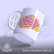 Чашка жіноча Розквітай щомиті, біла з кольоровим принтом, на якому написано 'Розквітай щомиті!' з квітковими елементами, ручка округла, край рівний, глянцевий фініш, фон світло-фіолетовий з легким малюнком.