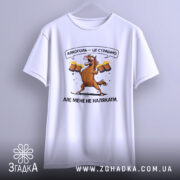 Футболка алкоголь це страшно, біла футболка, з принтом коня, що тримає пивні кухлі, фон світло-фіолетовий, текст на футболці: 'Алкоголь — це страшно. Але мене не налякати.', футболка підвішена.