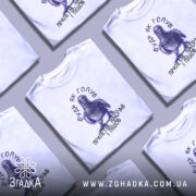 Футболка будь як голуб, біла, на моделі, з принтом голуба та текстом, фон світло-фіолетовий, деталі принта чіткі, кольорові акценти на очах голуба.