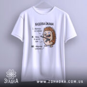 Футболка будова їжака, біла, підвішена на вішалці, ракурс спереду, фон світло-сірий, принт з їжаком, який тримає гвинтівку, текст з описом характеристик їжака.