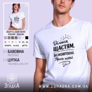 Футболка ділюся щастям. Біла футболка на чоловікові, з коротким рукавом, з принтом чорного кольору на грудях, на фоні світло-фіолетового кольору. Принт містить текст з позитивним посланням і малюнком сонця.