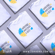 Футболка для найкращої вчительки, білого кольору, зображена на моделі в ракурсі спереду, фон ніжно-фіолетовий, принт з жовто-блакитним соняшником та написом 'найкраща вчителька в світі!' у чорному кольорі.