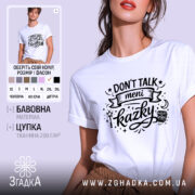 Футболка Don’t Talk мені казки білого кольору, зображена на моделі з коротким рукавом, фон ніжно-фіолетовий, принт чорного кольору з написом 'Don't Talk meni kazky' та декоративними елементами.