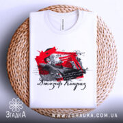 Футболка Джозеф Конрад, біла, складена на плетеній основі, фон світло-сірий, принт з червоними та чорними елементами, зображення чоловіка та текст.