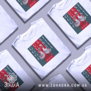 Футболка GUSSI з гусьми, біла, зображена на моделі, ракурс спереду, фон світло-фіолетовий, принт з двома гусьми на червоному та зеленому фоні з написами GUSSI.