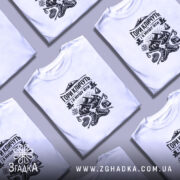 Футболка гори кличуть, біла, зображена на чоловікові, ракурс спереду, фон світло-фіолетовий, принт чорного кольору з горами, туристичним спорядженням та написом.