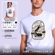 Футболка гори мій характер. Біла футболка з круглим вирізом, на моделі, з принтом, що зображує гори та річку, виконаним у чорному та золотому кольорах. Фон світло-фіолетовий, модель дивиться прямо в камеру.