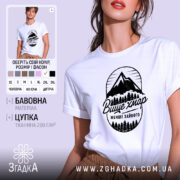 Футболка гори вище хмар, біла, зображена на моделі з легким ракурсом, фон ніжно-фіолетовий, принт з горами та деревами чорного кольору з написом 'Вище хмар менше зайвого'.