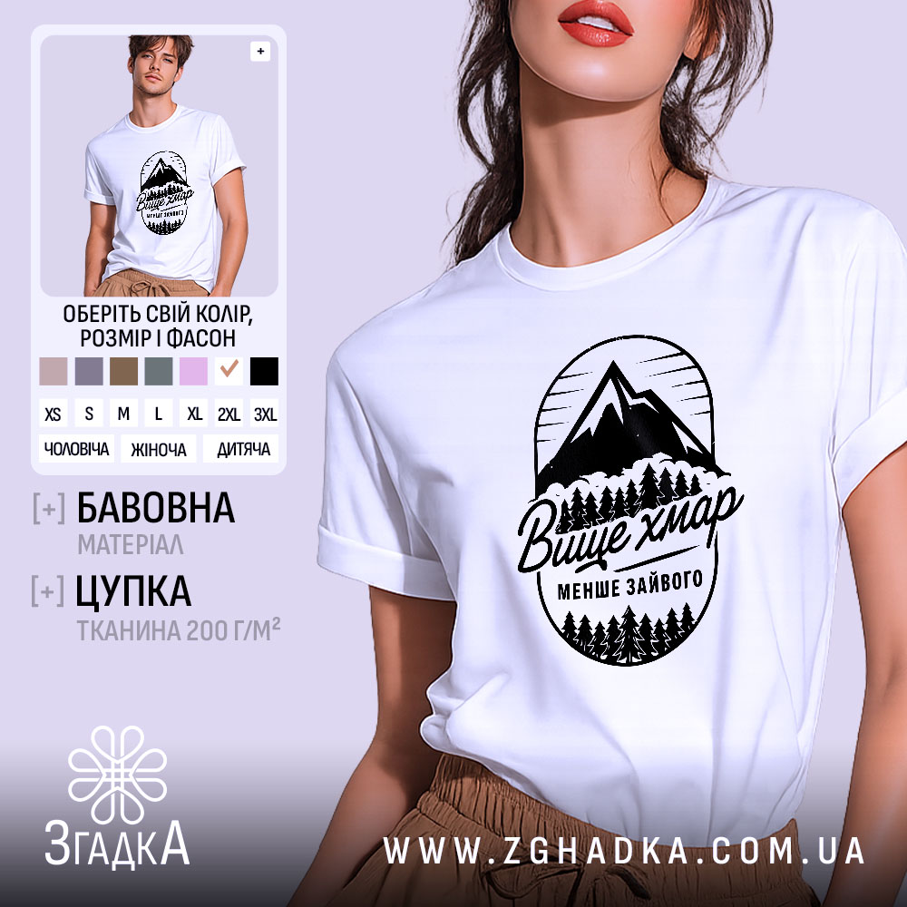 Futbolka Hory Vyshche Khmar Minimum Zaivoho 1 Футболка гори вище хмар, біла, зображена на моделі з легким ракурсом, фон ніжно-фіолетовий, принт з горами та деревами чорного кольору з написом 'Вище хмар менше зайвого'.