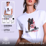 Футболка йду в комплекті з валідолом, біла, зображена на моделі з коротким рукавом, фон світло-фіолетовий, принт з жінкою в масці кота з червоними мазками на фоні та написом.