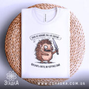 Футболка Їжак не ніжний, біла, зображена на плетеній основі, фон світлий, принт з їжаком з ножем, текст зверху принта, видно етикетку на горловині.