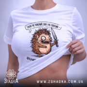 Футболка Їжак не ніжний, біла, зображена в горизонтальному положенні, фон світлий, принт з їжаком з ножем, текст зверху принта, на футболці є етикетка.