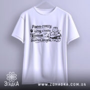 Футболка хочу стати котом. Біла футболка, підвішена на вішалці, зображена з фронтального ракурсу. Принт чорного кольору з котом, який сидить на грошах, з текстом "Рівень стресу: хочу стати котом багатих людей".