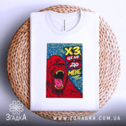 Футболка ХЗ білого кольору, зображена зверху на плетеній кошику, фон світлий, принт з червоним ведмедем, що кричить, на синьому фоні.