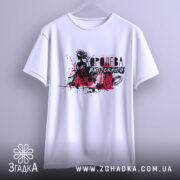 Футболка Королева випускного білого кольору, підвішена на вішалці, фон світло-сірий, принт з чорними та червоними елементами, що зображає силует дівчини в короні.