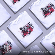 Футболка Королева випускного білого кольору, зображена на моделі з коротким рукавом, фон ніжно-фіолетовий, принт з чорними та червоними елементами, що зображає силует дівчини в короні.