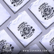 Футболка краще в горах — кілька складених футболок, композиція на столі.