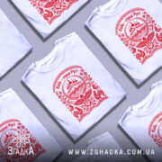 Футболка Київ серце Русі, біла, на моделі, з червоним принтом, фон світло-сірий, принт з зображенням церкви та елементами українського орнаменту.