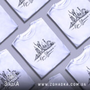 Футболка Київ Україна, біла, на моделі, фон світло-фіолетовий, принт зображує архітектурні пам'ятки Києва, напис 'Kyiv, Ukraine' під малюнком.