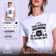 Футболка киця зайнята, біла, на моделі, з легким ракурсом спереду, фон світло-фіолетовий, принт чорного кольору з зображенням кота та текстом.