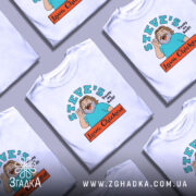 Футболка Лава Чікен, біла, на моделі, з легким ракурсом спереду, фон світло-фіолетовий, принт з веселим персонажем, що махає рукою, текстом 'STEVE'S Tasty as hell!' та логотипом 'Lava Chicken'.