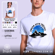 Футболка люблю бути зверху, біла, на моделі, фон світло-фіолетовий, принт з горами та небом, текст чорного кольору.