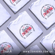 Футболка любов підтримка, біла, зображена на моделі з легким ракурсом, фон ніжно-фіолетовий, принт з малюнком двох персонажів у старості, текст на футболці чорного кольору з червоним словом 'любов'.