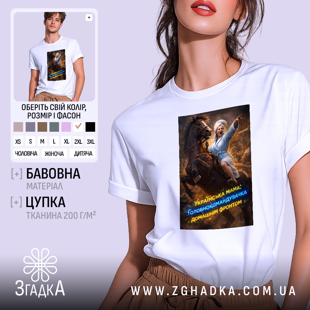 Футболка мама головнокомандувачка, білого кольору, зображена на моделі, яка стоїть на фоні світлого градієнта, принт з жінкою в халаті на коні, що вказує вперед, з яскравими кольорами та текстом.