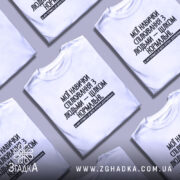 Футболка Моя терпимість, біла, зображена на моделі з коротким рукавом, фон світло-фіолетовий, принт чорного кольору з текстом на українській мові, розташований по центру.