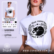 Футболка Моя тиша, біла, на моделі, з легким макіяжем, фон світло-фіолетовий, принт з зображенням сплячого лиса в обрамленні рослинних мотивів і сердець.