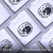 Футболка Моя тиша, біла, на моделі, з легким макіяжем, фон світло-фіолетовий, принт з зображенням сплячого лиса в обрамленні рослинних мотивів і сердець.