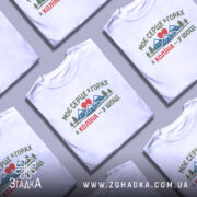 Футболка моє серце в горах — кілька складених футболок, композиція на столі.