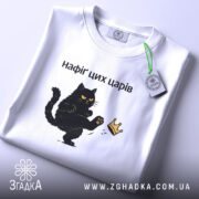 Футболка нафіґ цих царів, біла, складена на поверхні, з принтом чорного кота, який піднімає лапу до корони, фон світло-фіолетовий, деталі принта чіткі, текст чорний.