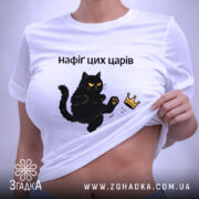 Футболка нафіґ цих царів, біла, складена на поверхні, з принтом чорного кота, який піднімає лапу до корони, фон світло-фіолетовий, деталі принта чіткі, текст чорний.