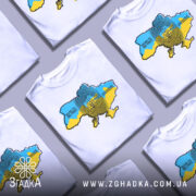 Футболка народжений вільним, біла, на моделі з коротким рукавом, фон світло-фіолетовий, принт з картою України в жовто-блакитних кольорах та текстом 'BORN TO BE FREE' і 'НАРОДЖЕНИЙ БУТИ ВІЛЬНИМ'.