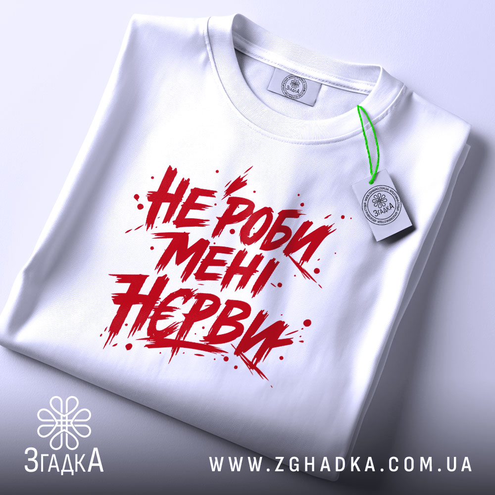 Футболка не роби мені нєрви, біла, складена на поверхні, фон світло-сірий, принт червоний з агресивним шрифтом, текст займає центральну частину, на комірці є етикетка.