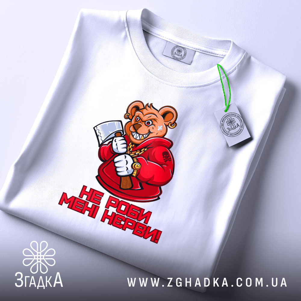 Футболка не роби мені нєрви. Біла футболка, зображена зверху, ведмідь в червоному капюшоні з сокирою, текст "НЕ РОБИ МЕНІ НЕРВИ!" під малюнком, на фоні світло-сірого кольору, з етикеткою на комірці.
