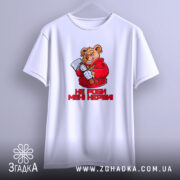 Футболка не роби мені нєрви. Біла футболка з коротким рукавом, ведмідь в червоному капюшоні з сокирою на фоні світло-сірого кольору, текст "НЕ РОБИ МЕНІ НЕРВИ!" під малюнком, зображена з переднього ракурсу.