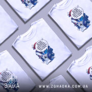 Футболка Не треба повторювати. Біла футболка на моделі, з коротким рукавом, з принтом на грудях, що зображує кролика на космічному фоні з текстом. Модель позує на світлому фоні, з легким макіяжем і розпущеним волоссям.