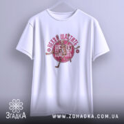 Футболка нехай щастить білого кольору, підвішена на вішалці, з принтом скелета, що біжить, та написом 'Нехай щастить' у червоному кольорі. Фон має світло-сірий відтінок.