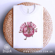 Футболка нехай щастить білого кольору, розташована на плетеній основі, з принтом скелета, що біжить, та написом 'Нехай щастить' у червоному кольорі. Видно етикетку з написом на комірці.