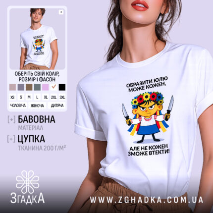 Футболка образити може кожен. Біла футболка на моделі, зображена з правого ракурсу. Фон світло-фіолетовий. Принт з ілюстрацією дівчинки в українському вбранні з квітковим вінком на голові, тримає ножі, текст зверху і знизу принта чорного кольору.