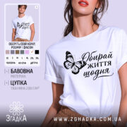 Футболка обирай життя щодня, біла, на моделі, з принтом метелика та написом, фон світло-фіолетовий, деталі принта чіткі та контрастні.