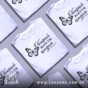 Футболка обирай життя щодня, біла, на моделі, з принтом метелика та написом, фон світло-фіолетовий, деталі принта чіткі та контрастні.