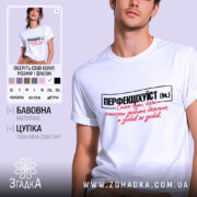 Футболка перфекціхуїст білого кольору, зображена на чоловікові, який позує з легким усмішкою. Принт на футболці чорного та червоного кольорів, розташований по центру, з текстом, що говорить про ідеальність. Фон м'який, світлий, що підкреслює яскравість футболки.