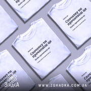 Футболка Спочатку ти прочитаєш, біла, на моделі з коротким рукавом, фон світло-фіолетовий, принт чорного кольору з текстом, розташованим по центру.