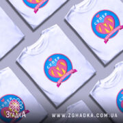 Футболка супер мама, біла, на моделі з коротким рукавом, фон світло-сірий, принт з написом 'СУПЕР' та серцем, кольори принта: рожевий, жовтий, блакитний.