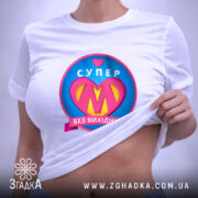 Футболка супер мама, біла, з плоским ракурсом, фон світло-сірий, принт з написом 'СУПЕР' та серцем, кольори принта: рожевий, жовтий, блакитний, з етикеткою на комірці.