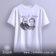 Футболка Тарас і Леся, біла, підвішена на вішалці, ракурс спереду, фон світло-сірий, принт з малюнком Тараса Шевченка та Лесі Українки, текст "Тарас & Леся" над малюнком.