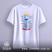 Футболка тато завжди правий, біла, підвішена на вішалці, фон світлий, принт з написом 'ТАТО' у блакитному кольорі, корона жовта, деталі тексту навколо.